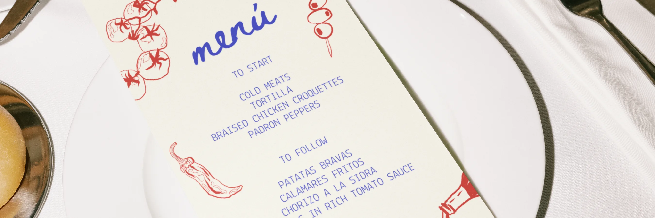 The Sol y Sal Kitchen menu laid on a set table, beside a glass of red wine